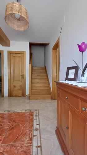 a room with a staircase and a table with a dresser at Casa Anibal in Burón