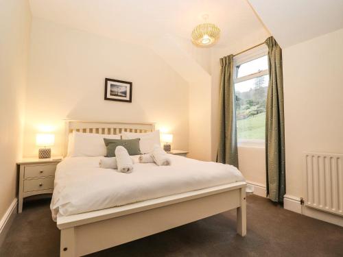 a bedroom with a large bed with a window at Waterhead Cottage in Ambleside