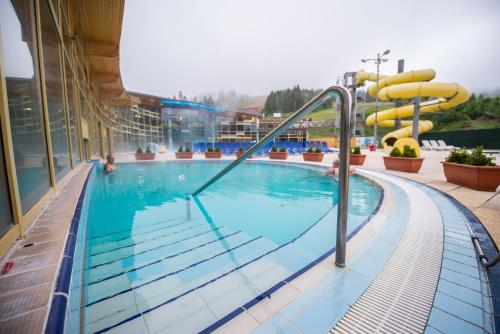 a swimming pool with a slide in a building at MEANDER THERMAL & SKI REZORT ORAVICE in Oravice