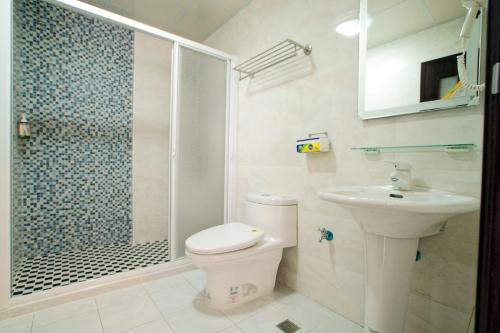 a bathroom with a shower and a toilet and a sink at Taiping Homestay in Taiping