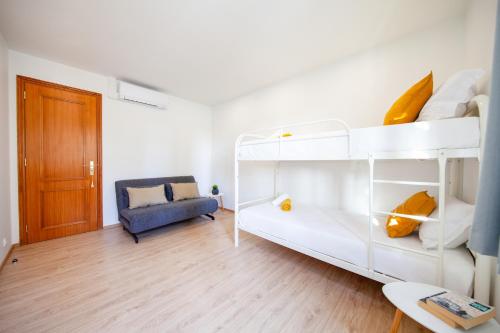 a small room with a bunk bed and a couch at Villa Haven - com jacuzzi e BBQ em Lagoa in Lagoa