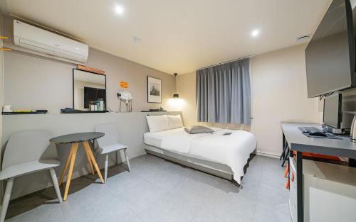 a hotel room with a white bed and a table at Hotel Yam Bucheon Station in Bucheon