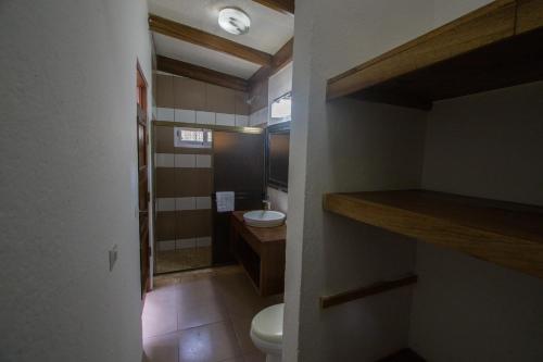 a small bathroom with a toilet and a sink at Hotel Ingigante in Rivas