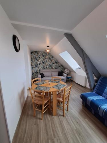 Studio l'écluse في لو تريبور: غرفة بها طاولة وكراسي وأريكة
