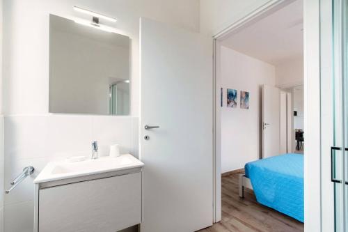a white bathroom with a sink and a mirror at Lake Como Retreat Menaggio in Menaggio