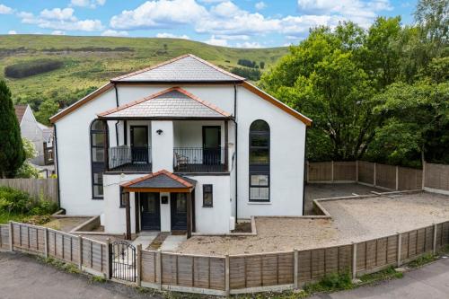 a white house with a fence in front of it at The Old Band Room House No 1 in Blaina
