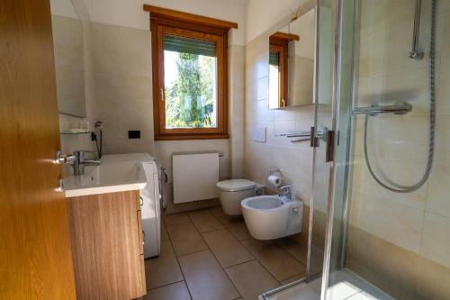 a bathroom with a toilet and a sink and a shower at Residence degli Oleandri APP A1 in Argegno