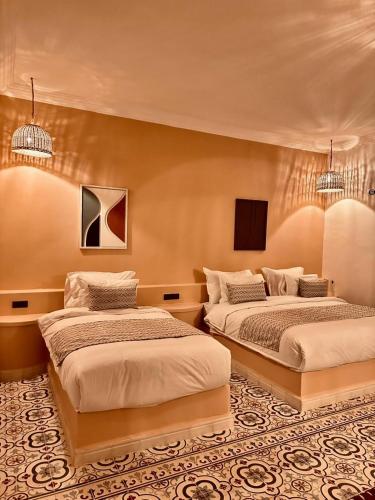 two beds in a hotel room with two at riad tighmart in Merzouga