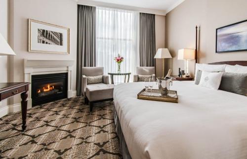 a hotel room with a bed and a fireplace at The Magnolia Hotel & Spa in Victoria