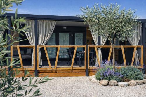 a house with a screened in porch with trees at Mobile homes Laguna, beach Porat, Drage in Drage