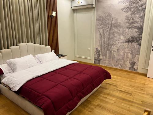 a bedroom with a large bed with a red blanket at The Royal Apartment at New Cairo in Cairo