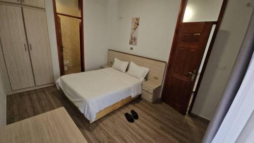 una piccola camera da letto con un letto bianco e una porta di Guest house ad Addis Abeba