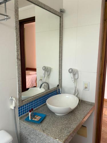a bathroom with a sink and a mirror at Pousada Paisagem in Paraty