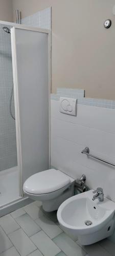 a white bathroom with a toilet and a sink at Midiè Savelletri in Savelletri di Fasano