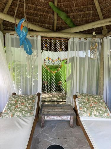 a room with two beds and a bird hanging from the ceiling at Pousada Paisagem in Paraty