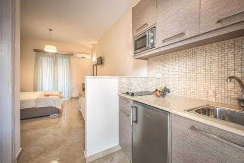 a kitchen with a sink and a bed in a room at Reparo Studios in Lithakia
