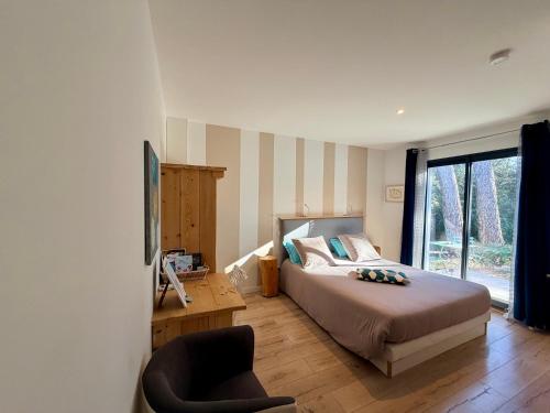 a bedroom with a bed and a chair and a window at CARPE DIEM Résidence Hôtelière in Lorgues