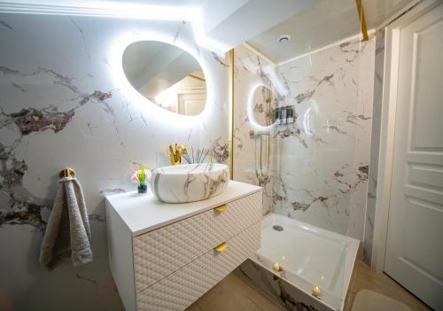 a bathroom with a sink and a mirror at Love Room Serenity Suite in Montbéliard