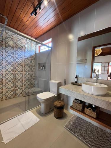 a bathroom with a toilet and a sink at Vilarejo Ibitipoca in Conceição da Ibitipoca