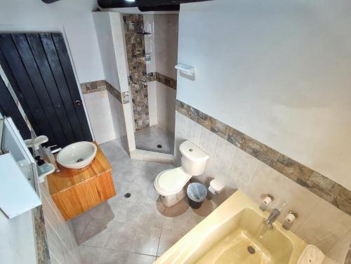 a bathroom with a toilet and a sink and a tub at La tranquera hotel in Villa de Leyva
