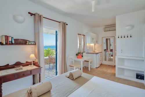 a bedroom with a bed and a view of the ocean at Glaros Studios Apartments in Antiparos