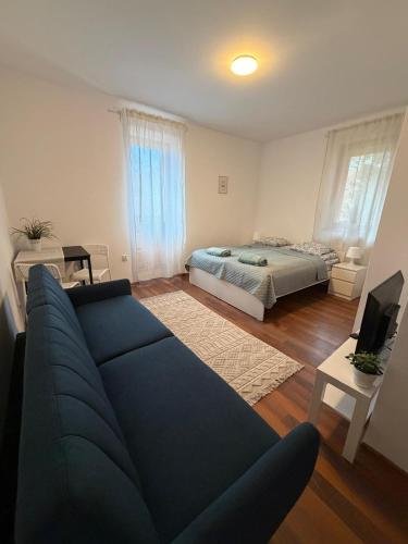 a living room with a blue couch and a bed at Dzikie Fiołki in Karpacz