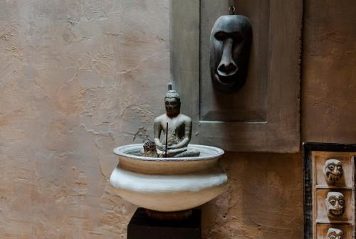 a statue sitting in a fountain next to a wall at Tara Luxury House in Habaraduwa Central