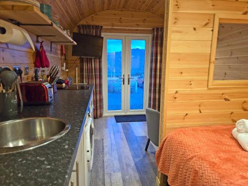 a kitchen with a sink and a bed in a room at Rowan Gorgeous Glamping Hideaway in Durnamuck