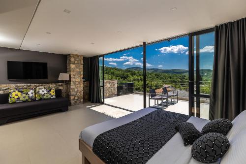 a bedroom with a king sized bed and a balcony at Villa Arija in Grižane