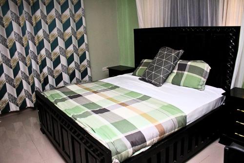 a bedroom with a bed with a checkered blanket at Mamboleo princely Homes in Kisumu