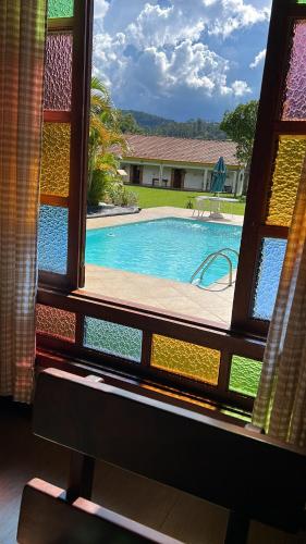 a view of a swimming pool through a window at Recanto da Maya in Santo Antônio do Pinhal