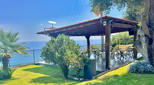 a wooden deck with tables and chairs on it at Villaggio Turistico La Fenosa in Marina di Camerota