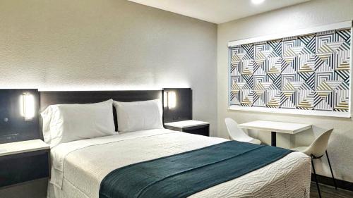 a hotel room with a bed and two tables at Motel 6-Atascadero, CA in Atascadero