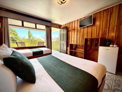 ein Hotelzimmer mit zwei Betten und einem Fernseher in der Unterkunft Mar Inn Costa Rica in Monteverde Costa Rica