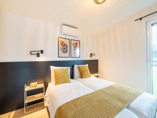 a bedroom with a large bed with yellow pillows at Bij de Bakker in Oud-Ade