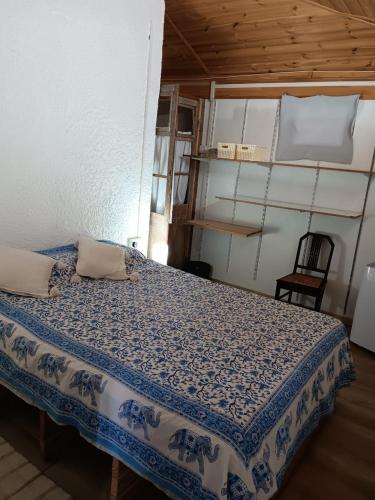 a bedroom with a blue and white bed with a chair at Acacia Retreat in Île La Fond