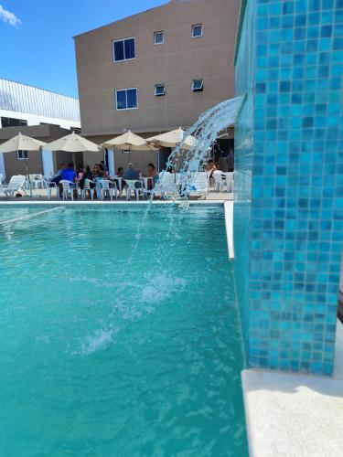 a pool with a water fountain in front of a hotel at Marechal Plaza Hotel in São Gabriel