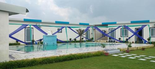 a bridge over a swimming pool in a building at Kamadgiri Green Valley in Nawābganj
