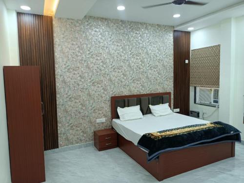 a bedroom with a bed and a wall at Kamadgiri Green Valley in Nawābganj