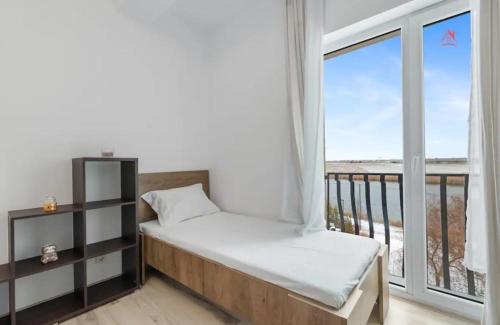 a bedroom with a bed and a large window at Apartament 2 dormitoare spatios, Aer conditionat, Flat Screen TV, Self Check-in in Ştefăneştii de Sus