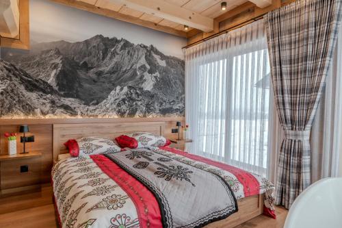a bedroom with a bed with a mountain mural on the wall at Domki Góralska Przystań in Białka Tatrzańska