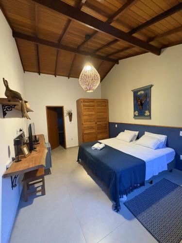 a bedroom with a bed and a desk with a computer at Vilarejo Ibitipoca in Conceição da Ibitipoca