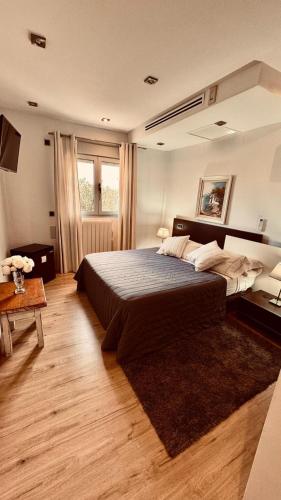 a bedroom with a large bed and a table at Red House Rooms in Llucmajor