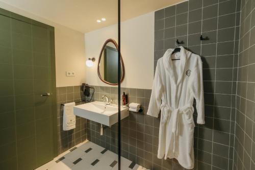 a bathroom with a white robe hanging on the wall at H Regas Adults Only in Barcelona