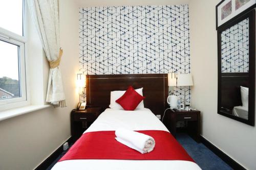 a dog laying on a bed in a bedroom at Acorn Lodge Hotel Gatwick & Parking in Horley