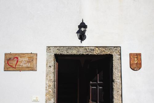a building with a door and a lamp and a sign at Cjasa da Puci in Ovaro