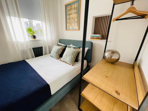 a small bedroom with a bed and a shelf at Cozy Organic Tea House in Central Ipswich near Waterfront, University and Hospital in Ipswich
