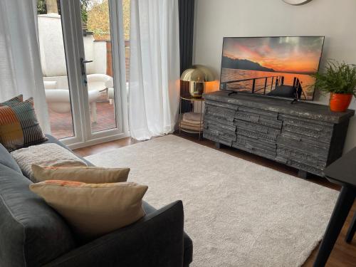 a living room with a couch and a flat screen tv at Cozy Organic Tea House in Central Ipswich near Waterfront, University and Hospital in Ipswich