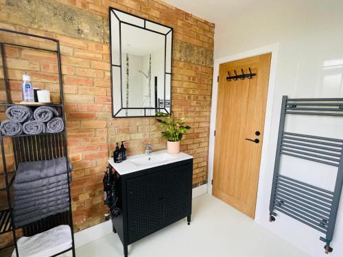 a bathroom with a sink and a brick wall at Cozy Organic Tea House in Central Ipswich near Waterfront, University and Hospital in Ipswich