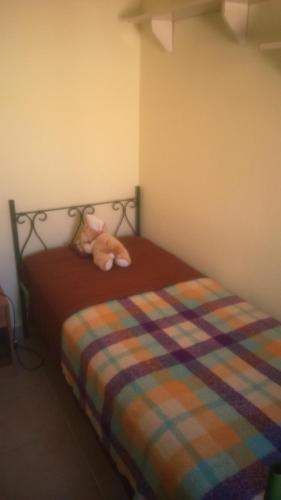 a teddy bear laying on a bed in a room at Arianna House in Raiano